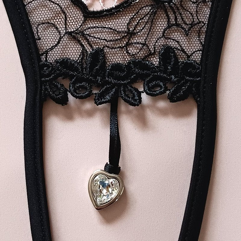 String sexy noir ajouré, sublimé par une fine dentelle noire et rose et un pendentif cœur décoratif au milieu.